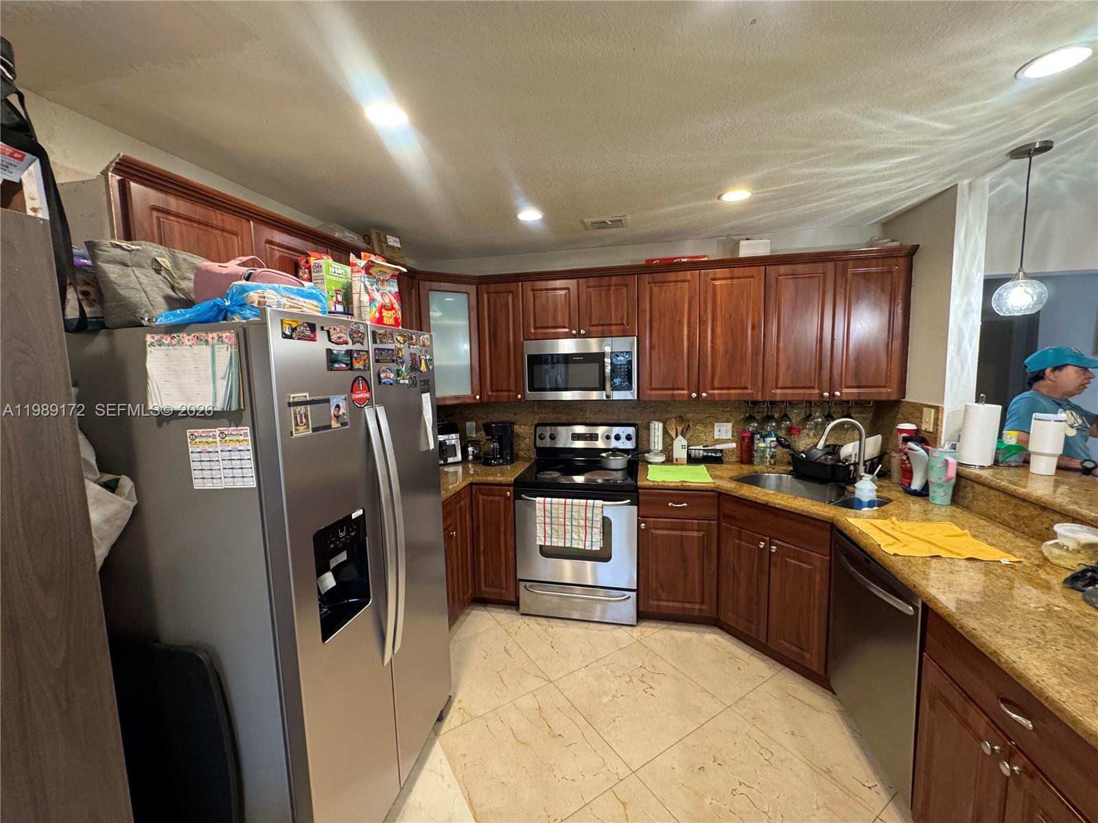 7632 Northwest 166th Terrace Hialeah, FL 33015 - Photo 4 of 20 a kitchen with stainless steel appliances granite countertop refrigerator a sink a stove top oven and a refrigerator