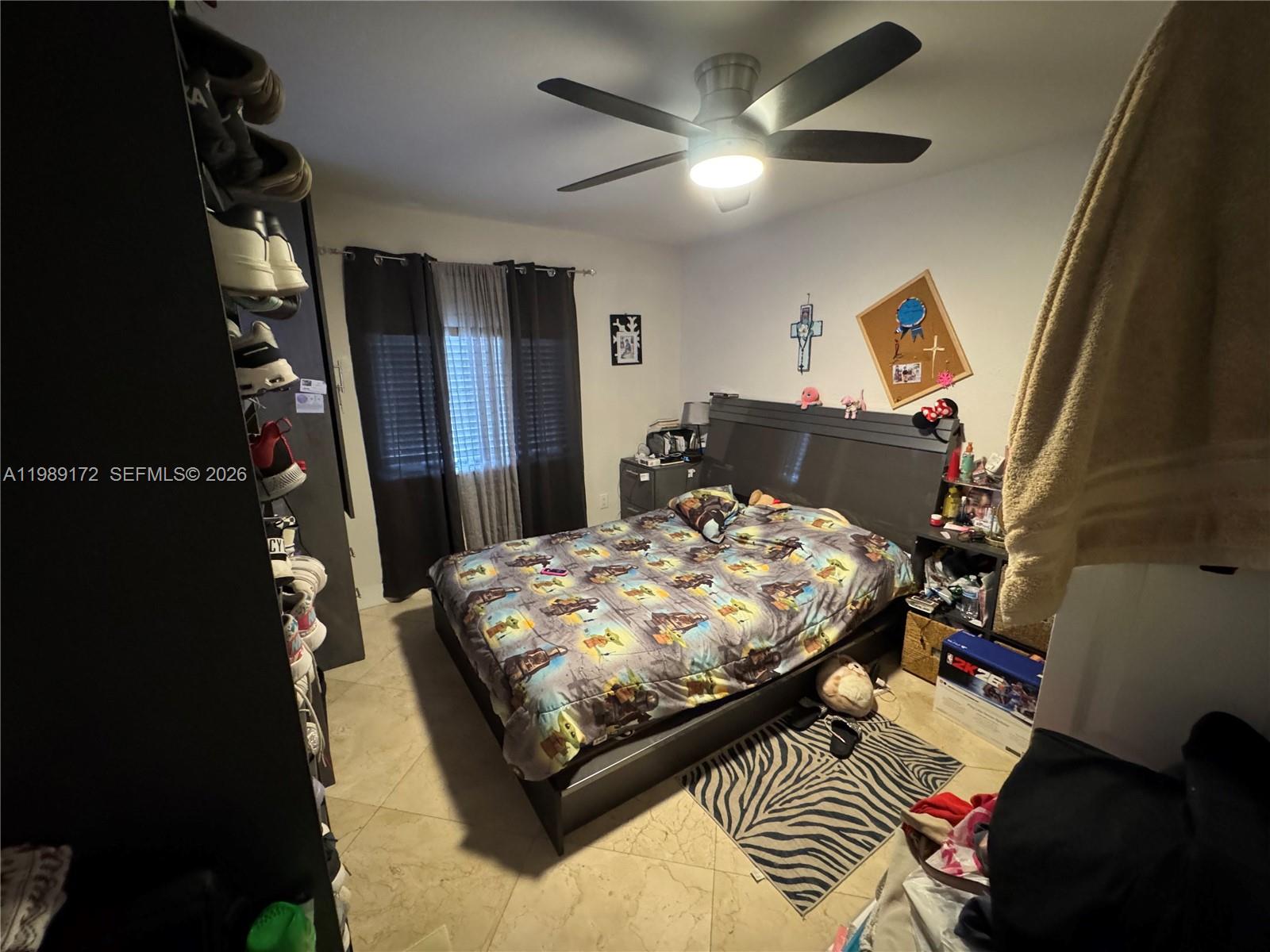 7632 Northwest 166th Terrace Hialeah, FL 33015 - Photo 8 of 20 a bed sitting in a bedroom next to a window