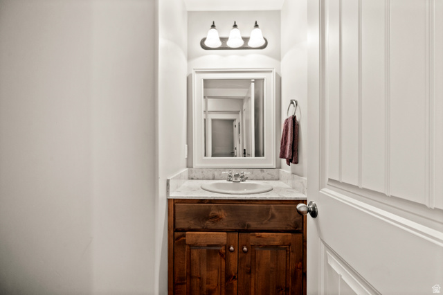 1145 North Christley Lane, Unit 48 Elk Ridge, UT 84651 - Photo 21 of 38 1/2 Bathroom vanity with a wood cabinet, undermount sink, and stone countertop