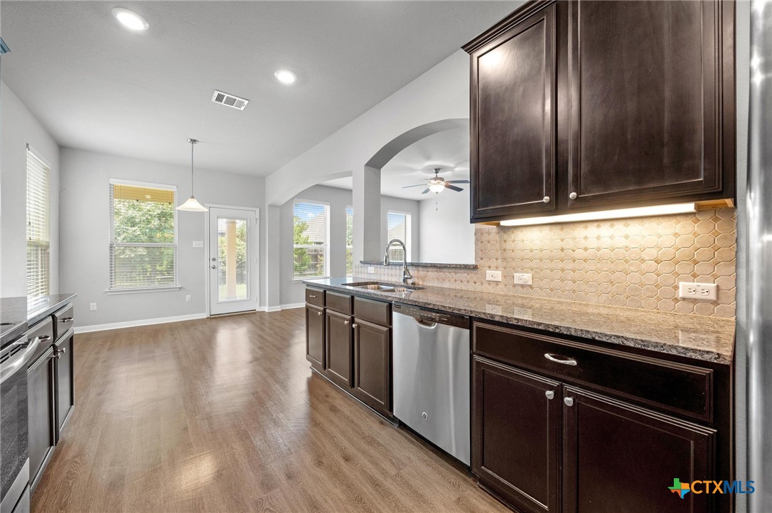 5338 Fenton Lane Belton, TX 76513 - Photo 12 of 33 a large kitchen with stainless steel appliances granite countertop a stove and a wooden floors