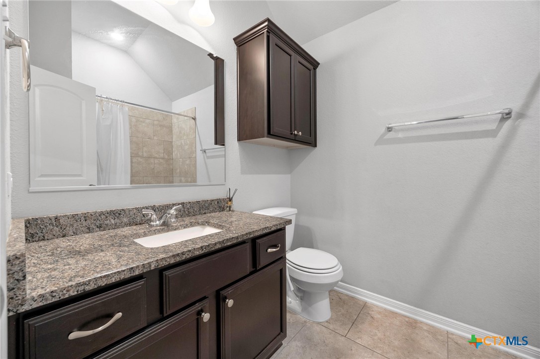 5338 Fenton Lane Belton, TX 76513 - Photo 26 of 33 a bathroom with a granite countertop sink a toilet and a mirror