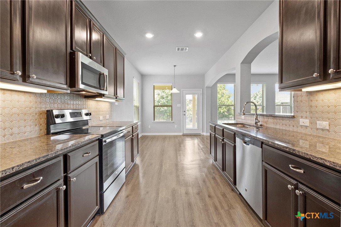 5338 Fenton Lane Belton, TX 76513 - Photo 9 of 33 a kitchen with stainless steel appliances granite countertop lots of counter space wooden floor and stainless steel appliances