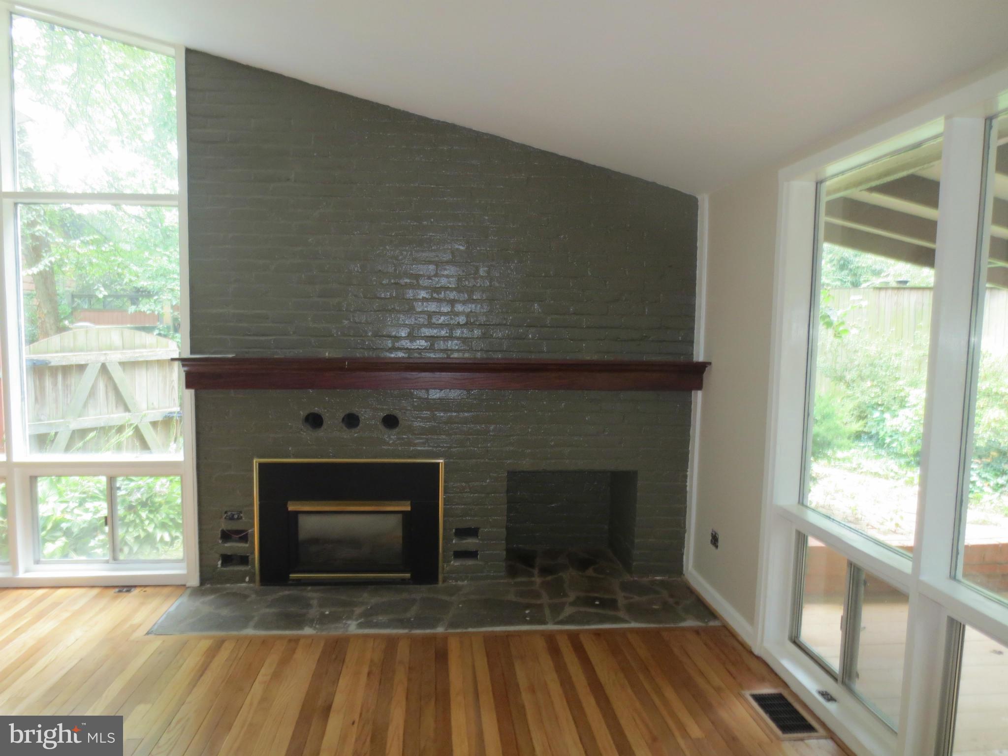 11532 Highview Avenue Silver Spring, MD 20902 - Photo 4 of 7 a living room with a fireplace and a floor to ceiling window