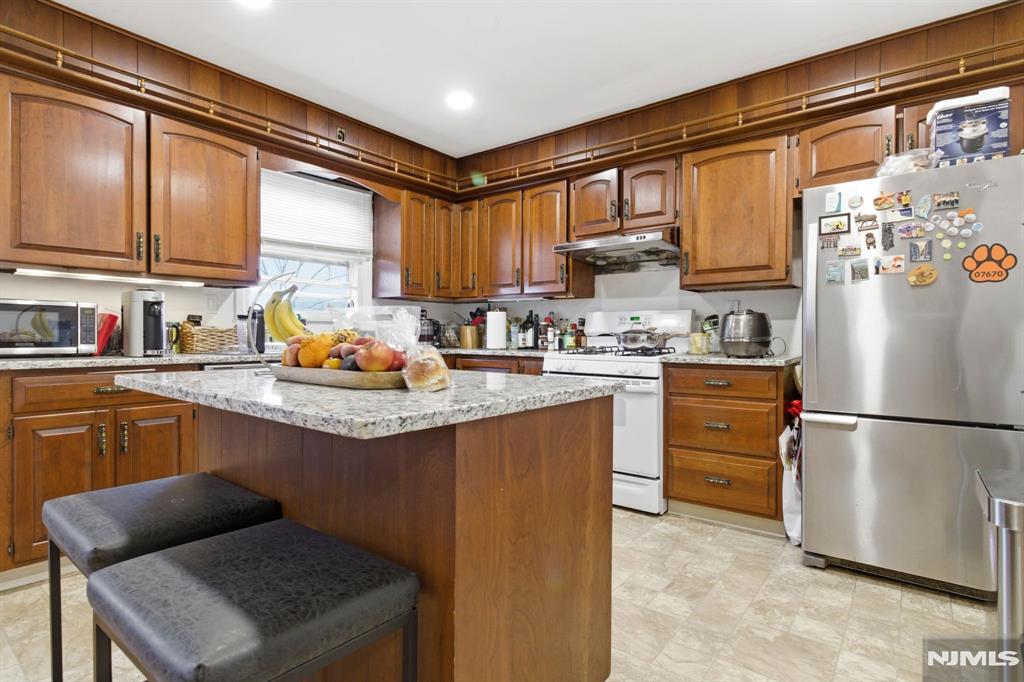 90 Cortlandt Place, Unit 2 Tenafly, NJ 07670 - Photo 2 of 3 a kitchen with stainless steel appliances granite countertop a refrigerator sink and wooden cabinets