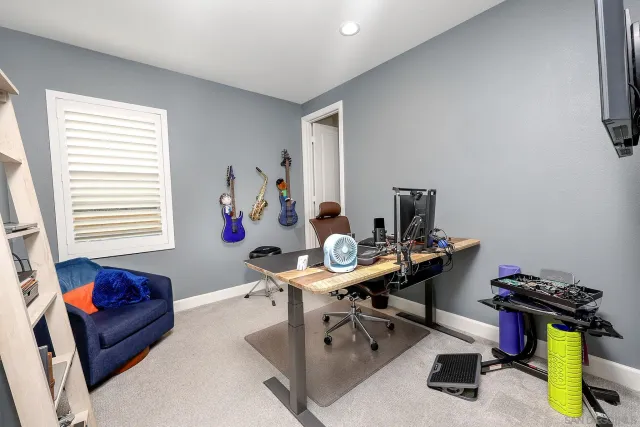a view of a workspace with furniture and a window