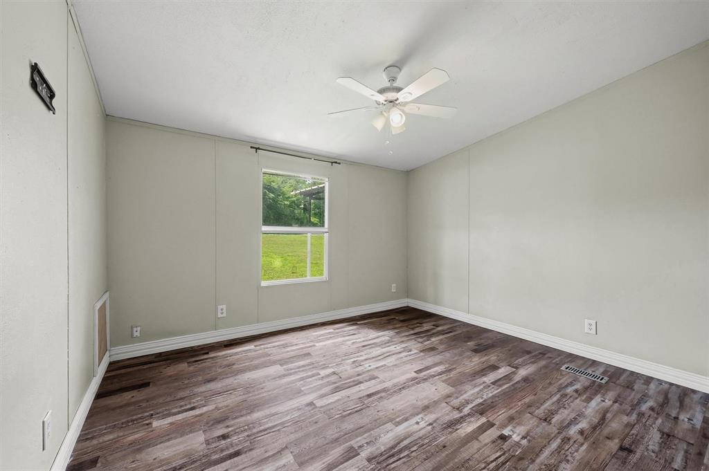 150 Gilbreath Road Sadler, TX 76264 - Photo 23 of 34 a view of an empty room with wooden floor and a window