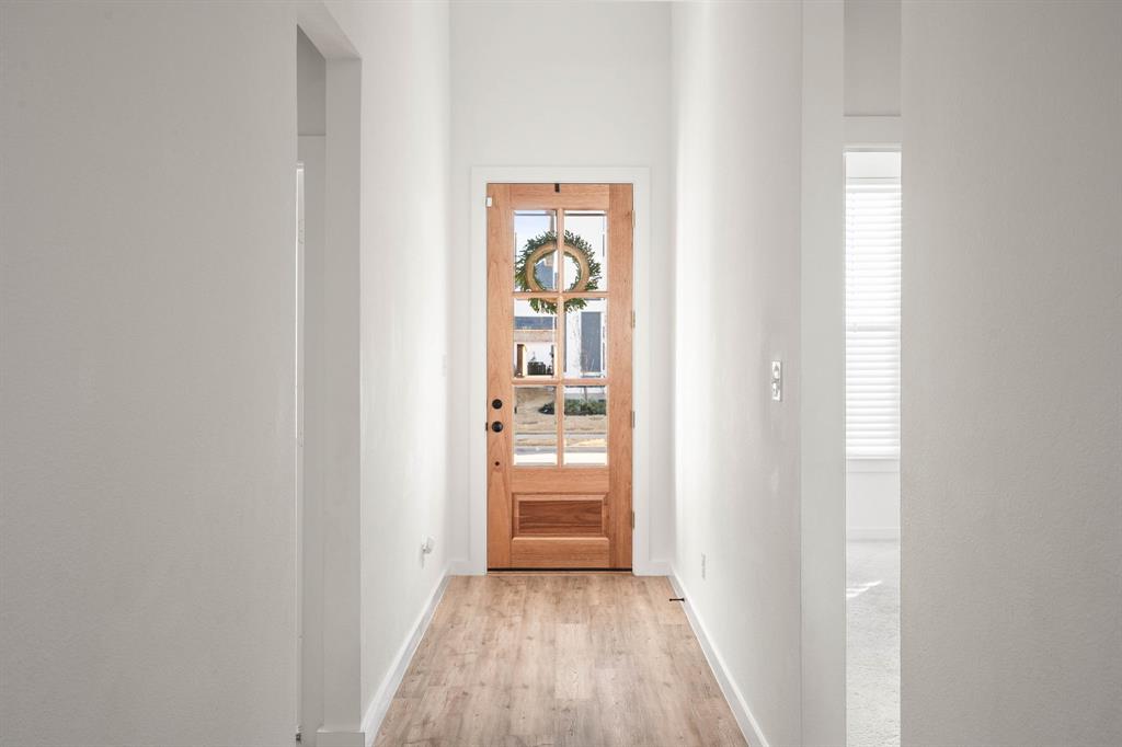 817 Isabel Street Celina, TX 75009 - Photo 3 of 39 a view of a hallway view with wooden floor and a bathroom