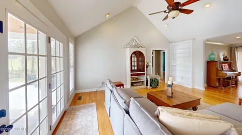 a living room with stainless steel appliances kitchen island granite countertop furniture and a large window