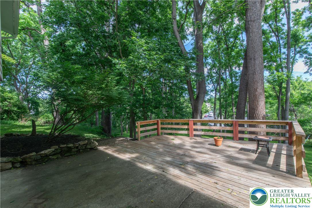 2011 Greenwood Road Allentown, PA 18103 - Photo 43 of 52 A spacious wooden deck provides a serene outdoor living area, embraced by verdant trees.