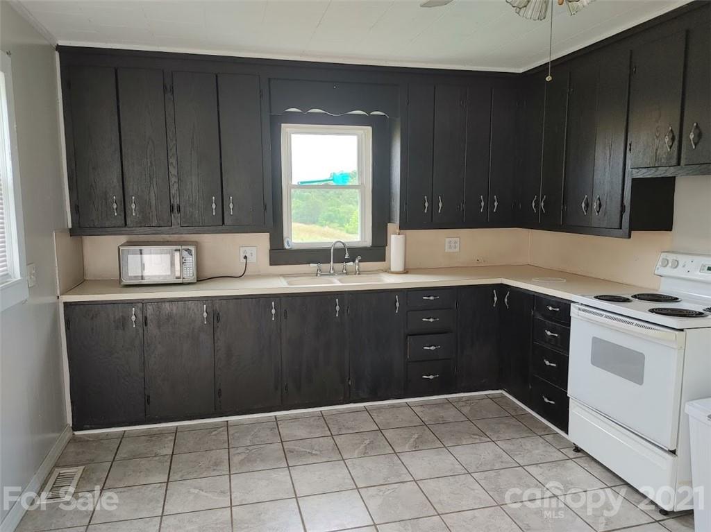 7312 Cheatham Ford Road Hiddenite, NC 28636 - Photo 7 of 16 a kitchen with a sink a stove and cabinets