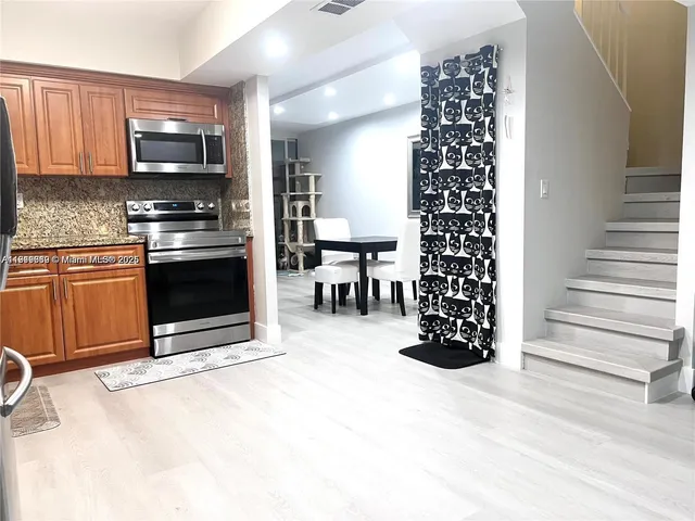 a kitchen with granite countertop a stove top oven and cabinets
