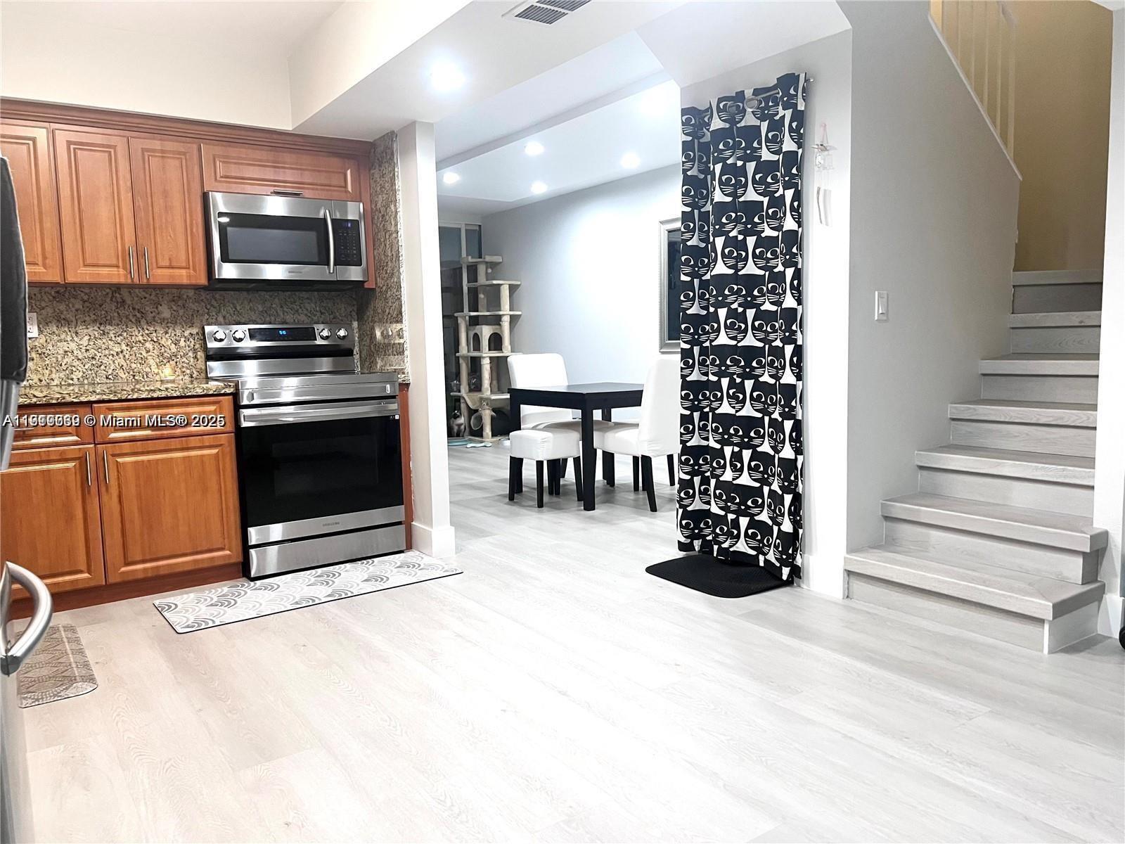 20200 West Country Club Drive, Unit 112 Aventura, FL 33180 - Photo 6 of 20 a kitchen with granite countertop a stove top oven and cabinets