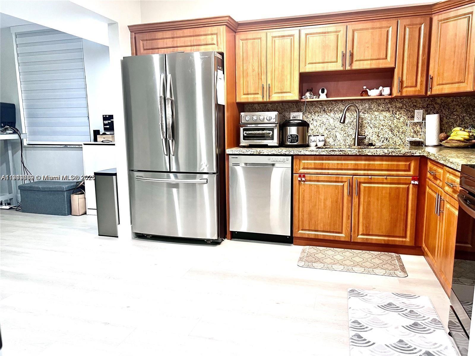 20200 West Country Club Drive, Unit 112 Aventura, FL 33180 - Photo 7 of 20 a kitchen with stainless steel appliances granite countertop a refrigerator sink and cabinets