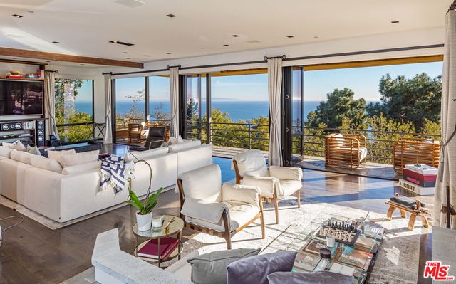 a living room with patio furniture and a large window
