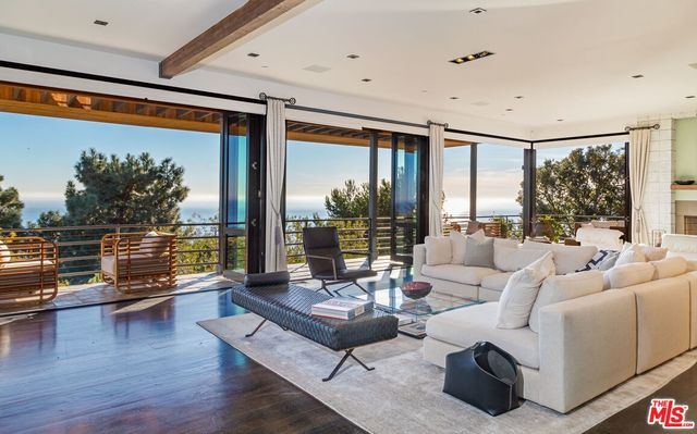 a living room with furniture and floor to ceiling window