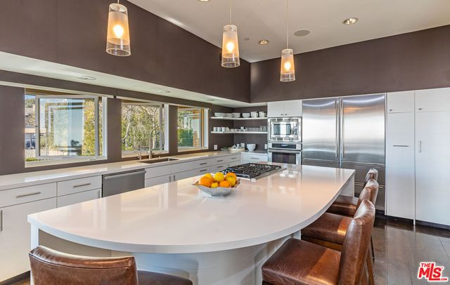 a kitchen with stainless steel appliances furniture and a large window