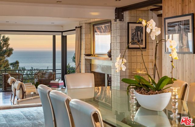 a dining room with furniture and a floor to ceiling window