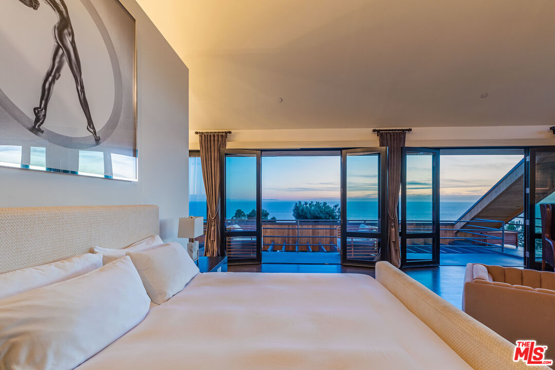 3900 Villa Costera Malibu, CA 90265 - Photo 21 of 43 a bedroom with furniture and large windows