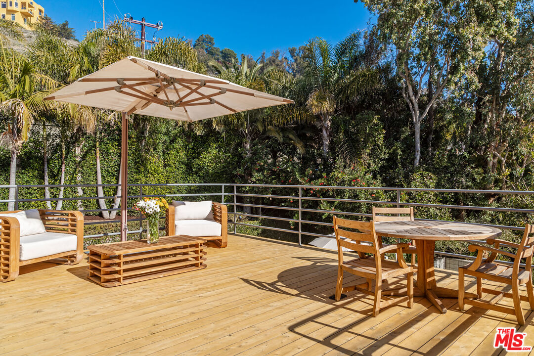 3900 Villa Costera Malibu, CA 90265 - Photo 38 of 43 a view of a patio with a table and chairs under an umbrella