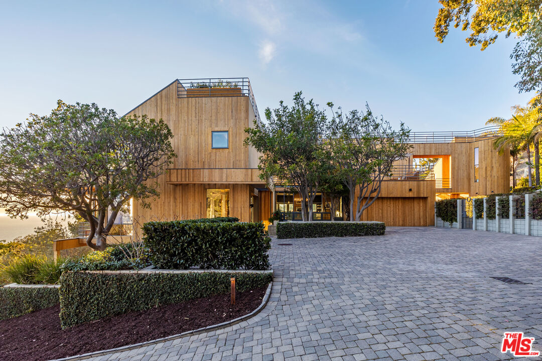 3900 Villa Costera Malibu, CA 90265 - Photo 40 of 43 a front view of a house with a yard and trees