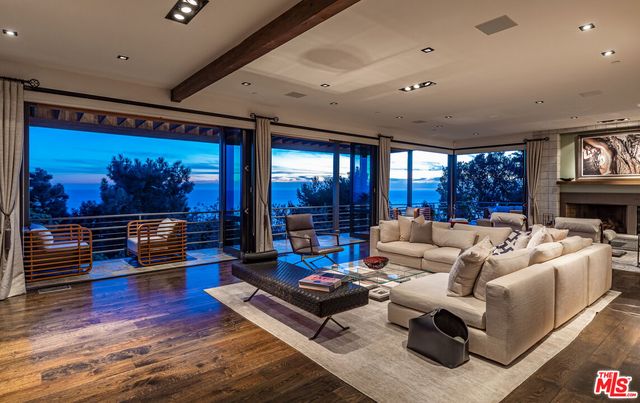 a living room with furniture a rug and a large window