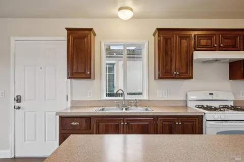 a kitchen with stainless steel appliances granite countertop a sink stove and cabinets