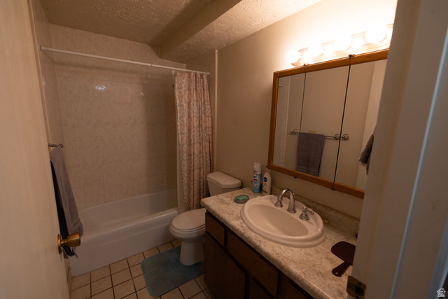314 West Center Street, Unit A83 Bountiful, UT 84010 - Photo 18 of 19 Bathroom featuring vanity, shower / tub combo with curtain, a textured ceiling, and light tile patterned flooring