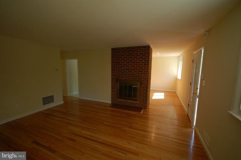 3612 Telmar Road Baltimore, MD 21207 - Photo 4 of 14 a view of a livingroom with wooden floor and a fireplace