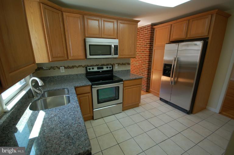 3612 Telmar Road Baltimore, MD 21207 - Photo 7 of 14 a kitchen with stainless steel appliances granite countertop a refrigerator stove and sink