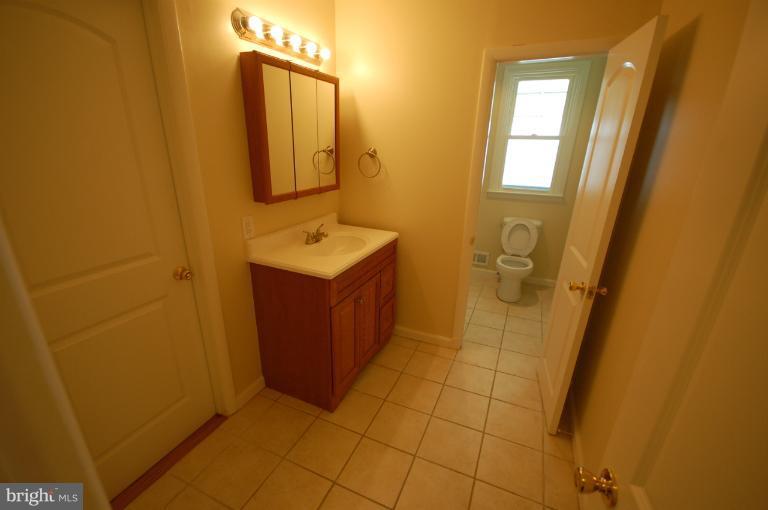 3612 Telmar Road Baltimore, MD 21207 - Photo 8 of 14 a bathroom with a sink a toilet and mirror
