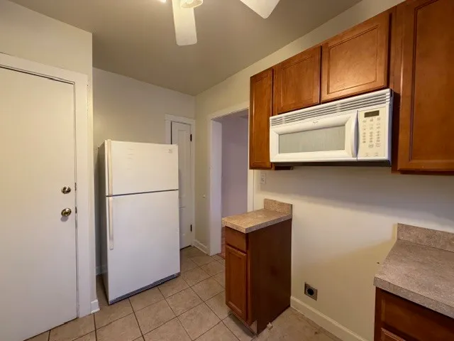 a kitchen with appliances a refrigerator and cabinets