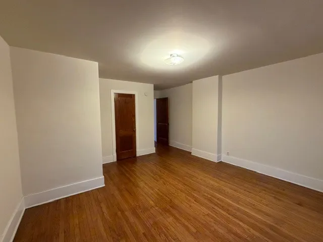 a view of an empty room with wooden floor