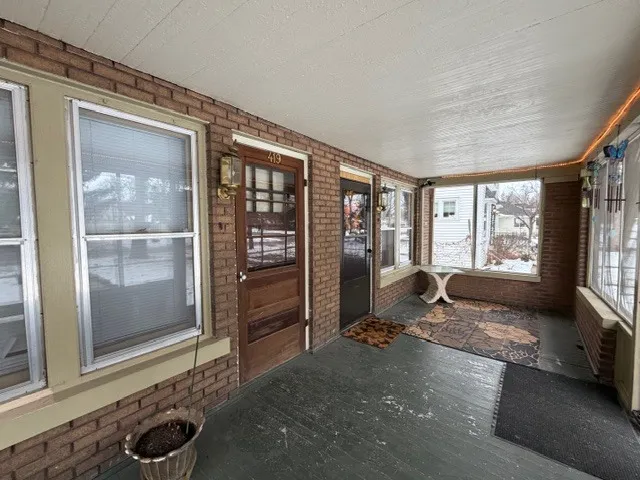 a living room with furniture a floor to ceiling window and potted plant