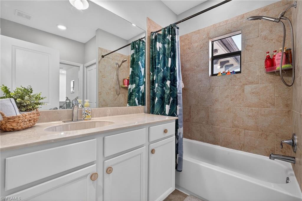 7845 Bristol Circle Naples, FL 34120 - Photo 22 of 31 a bathroom with a granite countertop sink a large mirror a shower and bathtub