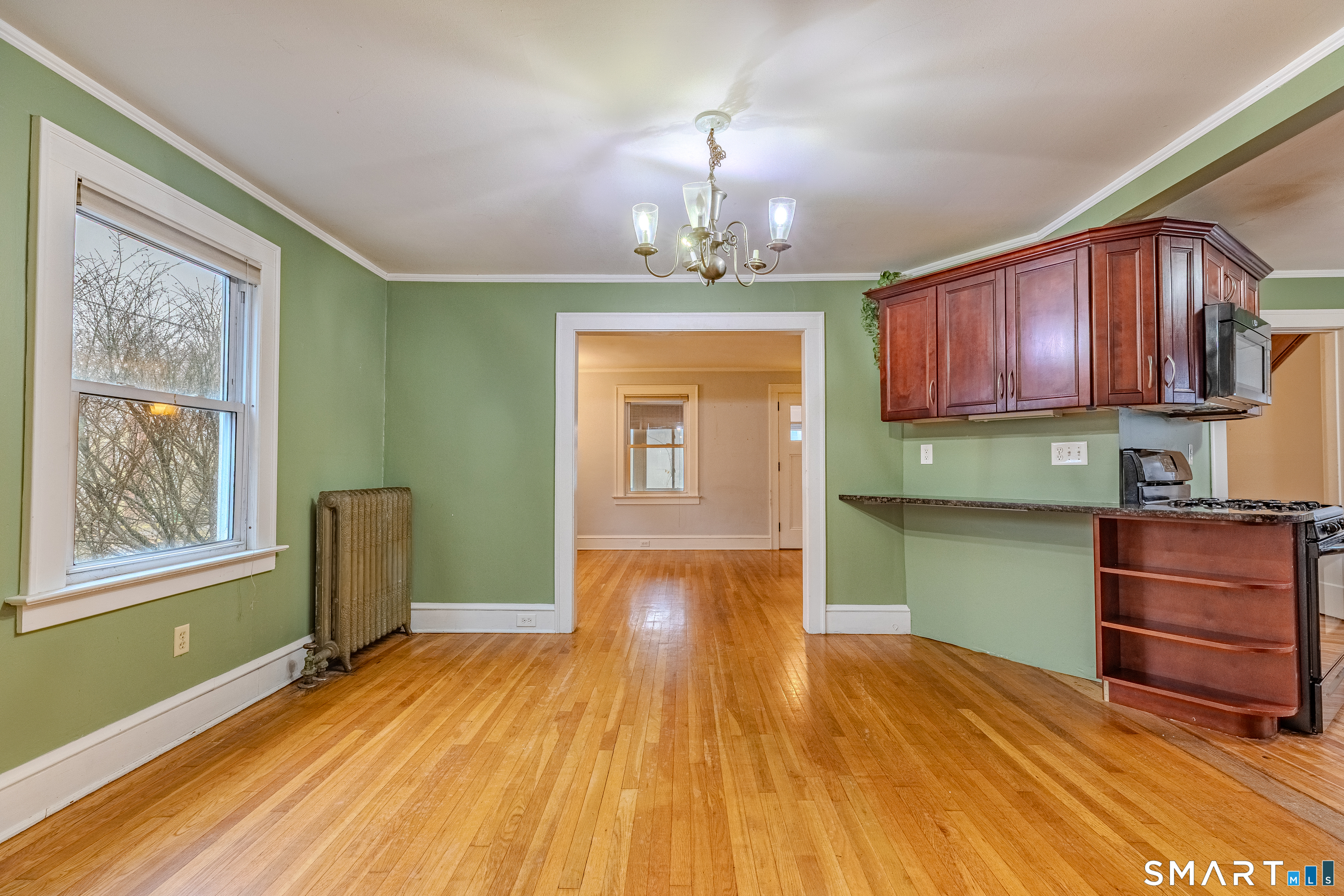 61 Woodmere Road West Hartford, CT 06119 - Photo 17 of 37 a kitchen with granite countertop wooden floors wooden cabinets a sink and a window