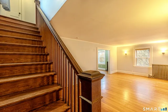 a view of entryway and hall with wooden floor