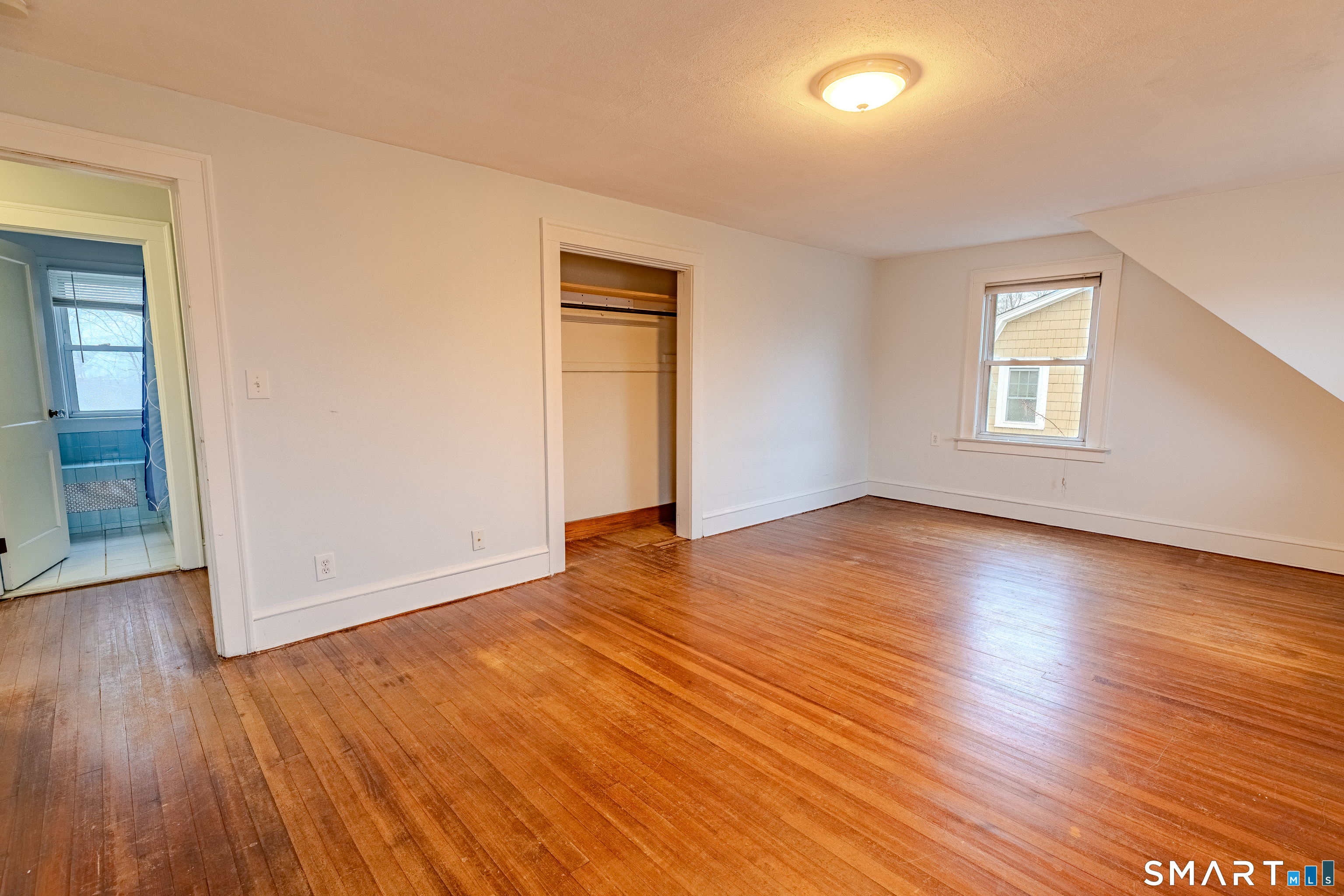 61 Woodmere Road West Hartford, CT 06119 - Photo 26 of 37 an empty room with wooden floor and windows