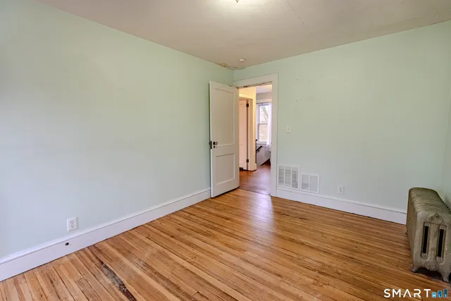 a view of empty room with wooden floor