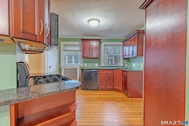 a kitchen with stainless steel appliances granite countertop a stove a sink and a microwave