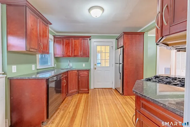 a kitchen with stainless steel appliances granite countertop a stove a sink and a refrigerator