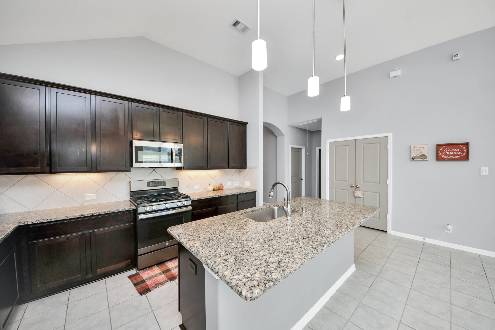 427 Alaska Cedar Drive Crosby, TX 77532 - Photo 14 of 35 a kitchen with stainless steel appliances granite countertop a stove and a sink