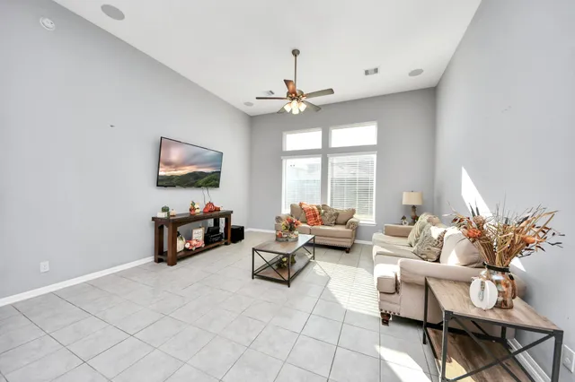 a living room with furniture a flat screen tv and a large window