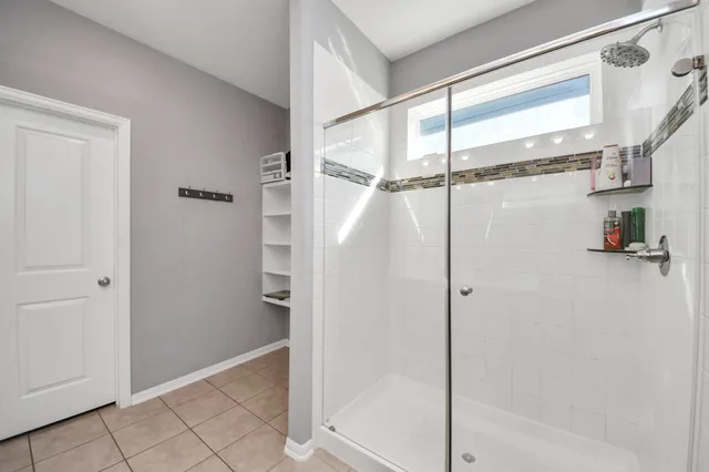 a bathroom with a shower and a glass door