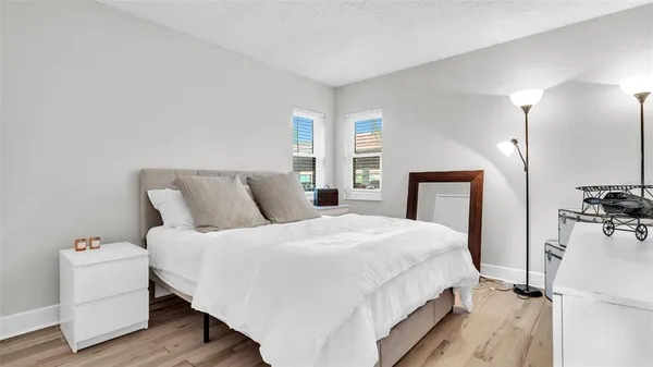 a bedroom with a bed a mirror and a lamp