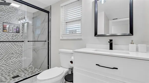 a bathroom with a sink a toilet and shower