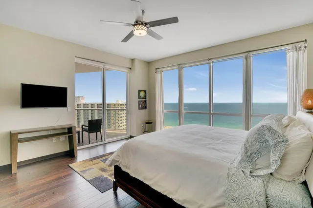 a spacious bedroom with a bed and a flat screen tv