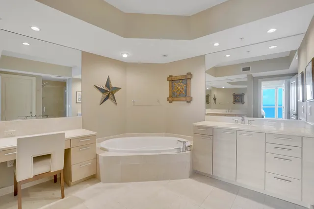 a bathroom with a tub a sink and a mirror