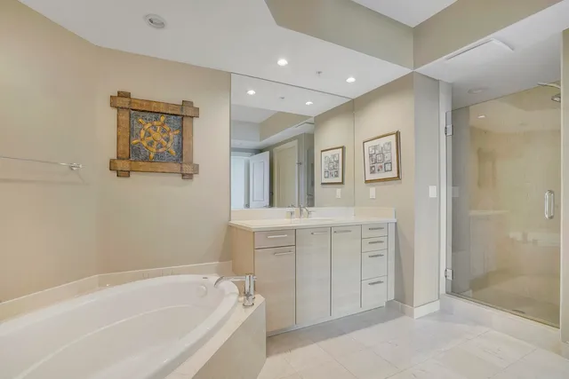 a spacious bathroom with a tub sink and mirror