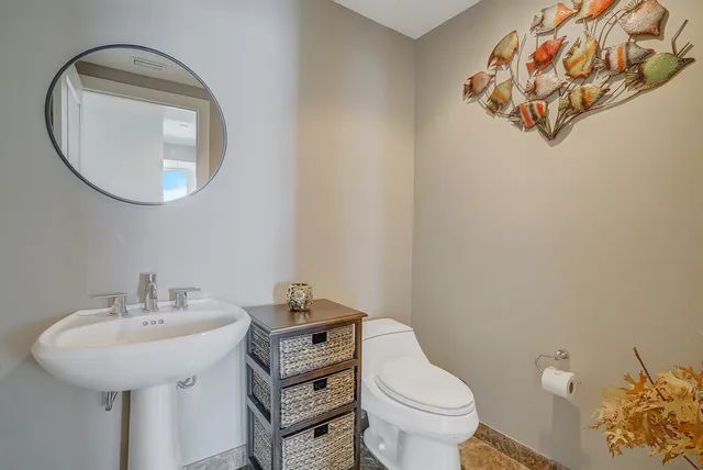a bathroom with a sink mirror and toilet