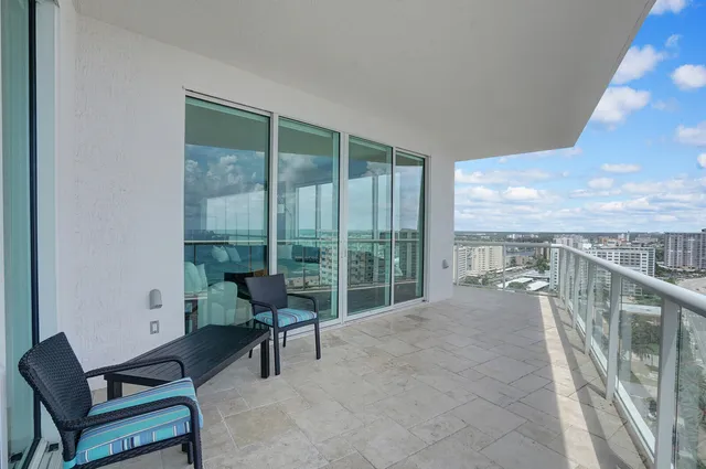a balcony with furniture and a floor to ceiling window